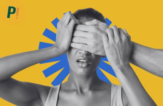 Arte mostra uma mulher em preto e branco com expressão de aflição enquanto mãos cobrem seus olhos e parte do rosto. Ao fundo amarelo, um elemento gráfico azul reforça a ideia de censura e silenciamento.