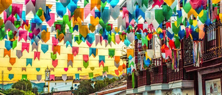 Brazilian june party (festas juninas) street decoration, with colorful flags and balloons over sunset sky