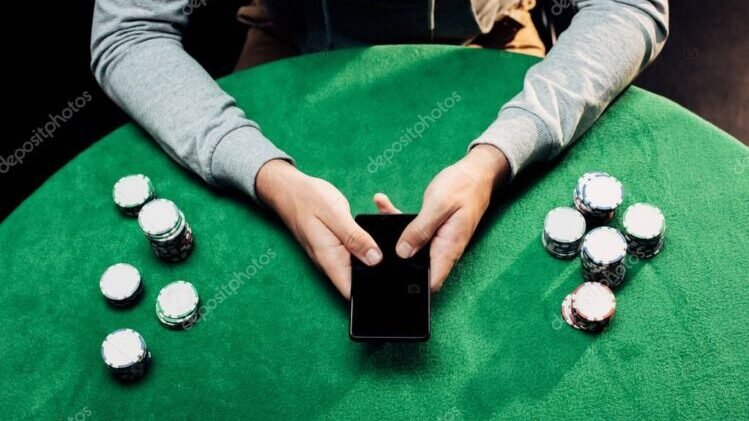 cropped view of man holding smartphone with blank screen near poker chips on black