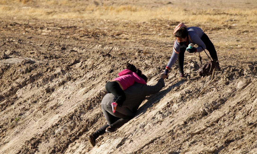 91871188 FILE PHOTO Migrants walk out of the Rio Bravo river after crossing it to turn themselves in